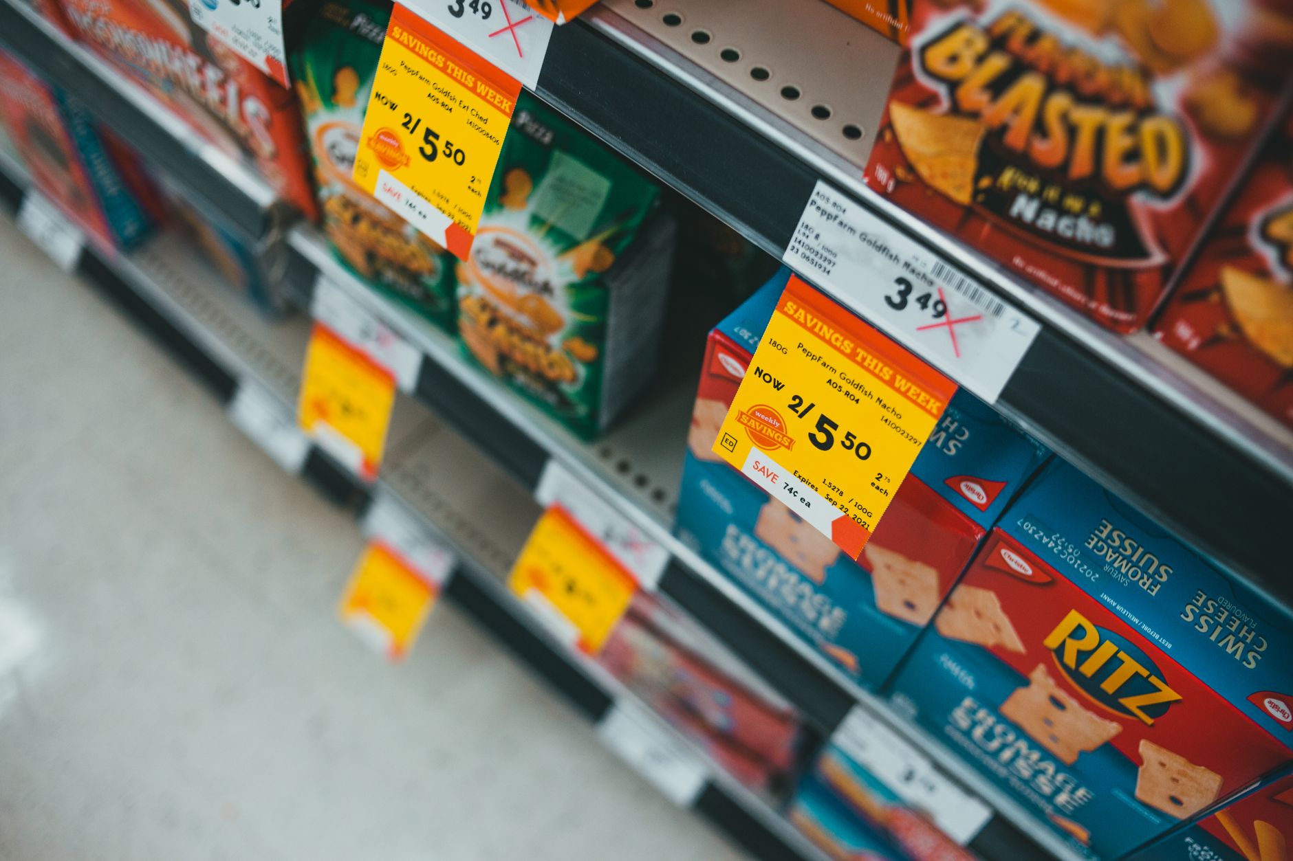 Supermarket aisle featuring discounted snacks with visible sale tags and prices.