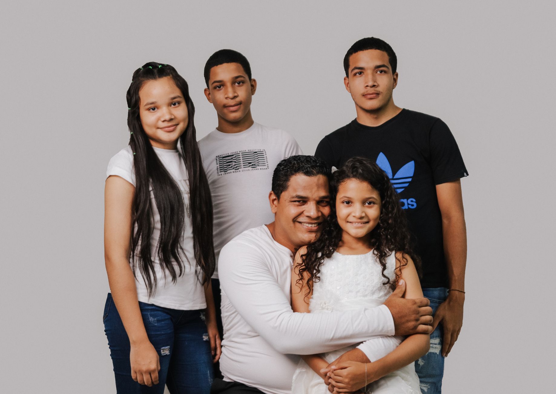 A father with his four children smiling warmly, depicting family love and togetherness.